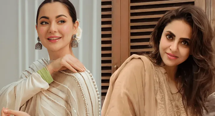 Two women in elegant attire: one in a light, embellished outfit with pearls; the other in a simple, traditional dress with flowing hair.