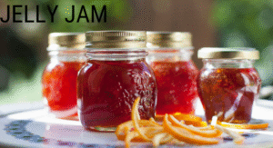 Foods Not to Refrigerate: 15 items That your Storing Wrong 12 Four jars of vibrant jelly jam with golden lids sit on a table, accompanied by strands of orange peels.