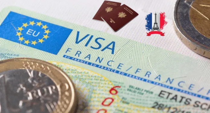 Close-up of a French visa, with two passports, a euro coin, and a graphic of the Eiffel Tower and French flag.