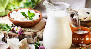 Top Foods That Increase Uric Acid & Effect Your Health: Try Their Alternatives 7 A glass jug of full fat milk beside bowls of cottage cheese and cream, with fresh herbs and flowers on a wooden table.