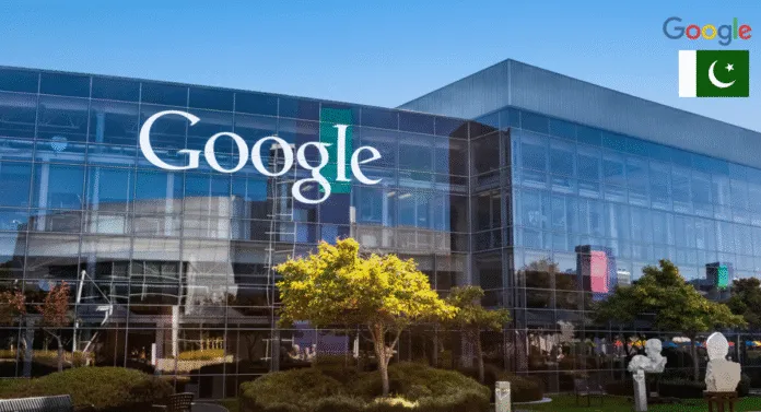Google's headquarters with large glass facade, featuring the Google logo and a small Pakistani flag in the corner. Bright, sunny day.