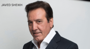 Love Guru Cast Spotlight: Mahira Khan, Humayun Saeed and More 4 Javed Sheikh, in a black suit and white shirt poses against a simple white backdrop, exuding professionalism and confidence.
