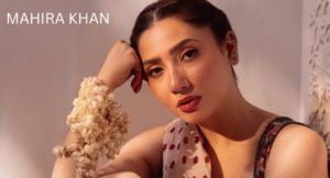 Love Guru Cast Spotlight: Mahira Khan, Humayun Saeed and More 2 A woman with a floral bracelet poses gracefully, wearing a colorful outfit against a soft-lit background. Text reads "MAHIRA KHAN."