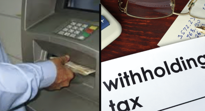 A hand withdrawing cash from an ATM alongside documents related to withholding tax on a wooden desk.