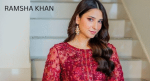 Love Guru Cast Spotlight: Mahira Khan, Humayun Saeed and More 7 Ramsha Khan, in a richly embroidered maroon dress with intricate details poses elegantly on a staircase, showcasing her stylish earrings.