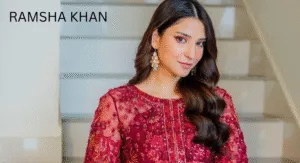 Love Guru Cast Spotlight: Mahira Khan, Humayun Saeed and More 7 Ramsha Khan, in a richly embroidered maroon dress with intricate details poses elegantly on a staircase, showcasing her stylish earrings.