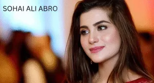 Love Guru Cast Spotlight: Mahira Khan, Humayun Saeed and More 8 Sohai Ali Abro, with long, flowing hair, wears a traditional outfit, standing against a softly blurred, colorful background.