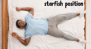 Best Sleeping Positions to Improve Sleep Quality for Healthy Lifestyle 5 A person lies on a bed in the starfish position, arms and legs spread out, wearing a light blue shirt and gray sweatpants.