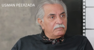 Love Guru Cast Spotlight: Mahira Khan, Humayun Saeed and More 6 Usman Peerzada, with silver hair and wearing a black shirt and scarf, sits against a blurred background.