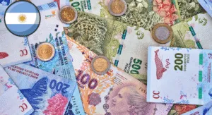 A collection of Argentine currency including various banknotes and coins, with the Argentine flag symbol in the upper left corner.