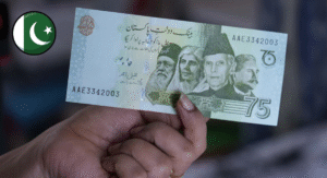 Top 13 Most Beautiful Banknote Designs Around the World 10 A close-up of a hand holding a 75 Pakistani Rupee note, featuring green and blue hues with text and design elements.