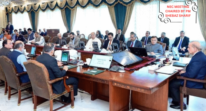 A formal meeting seated at a large wooden table with participants discussing and using electronic devices in a well-decorated room.