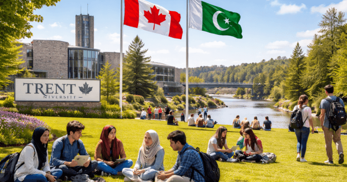 Students gather on the lawn of Trent University, with Canadian and Pakistani flags flying above a scenic river and greenery.
